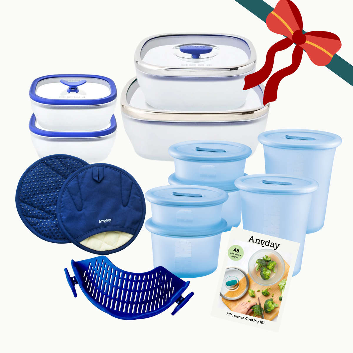 The Ultimate Gift Bundle (blue) containing glass dishes, translucent silicone storage, two blue pot holders, a blue rack, and a recipe booklet, decorated with a red ribbon.