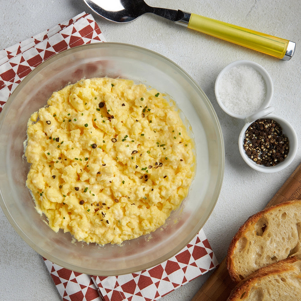 Perfectly cooked scrambled eggs made and served in the glass Anyday dish, providing fluffy and creamy eggs. This method ensures evenly cooked scrambled eggs, ideal for a quick and delicious breakfast.