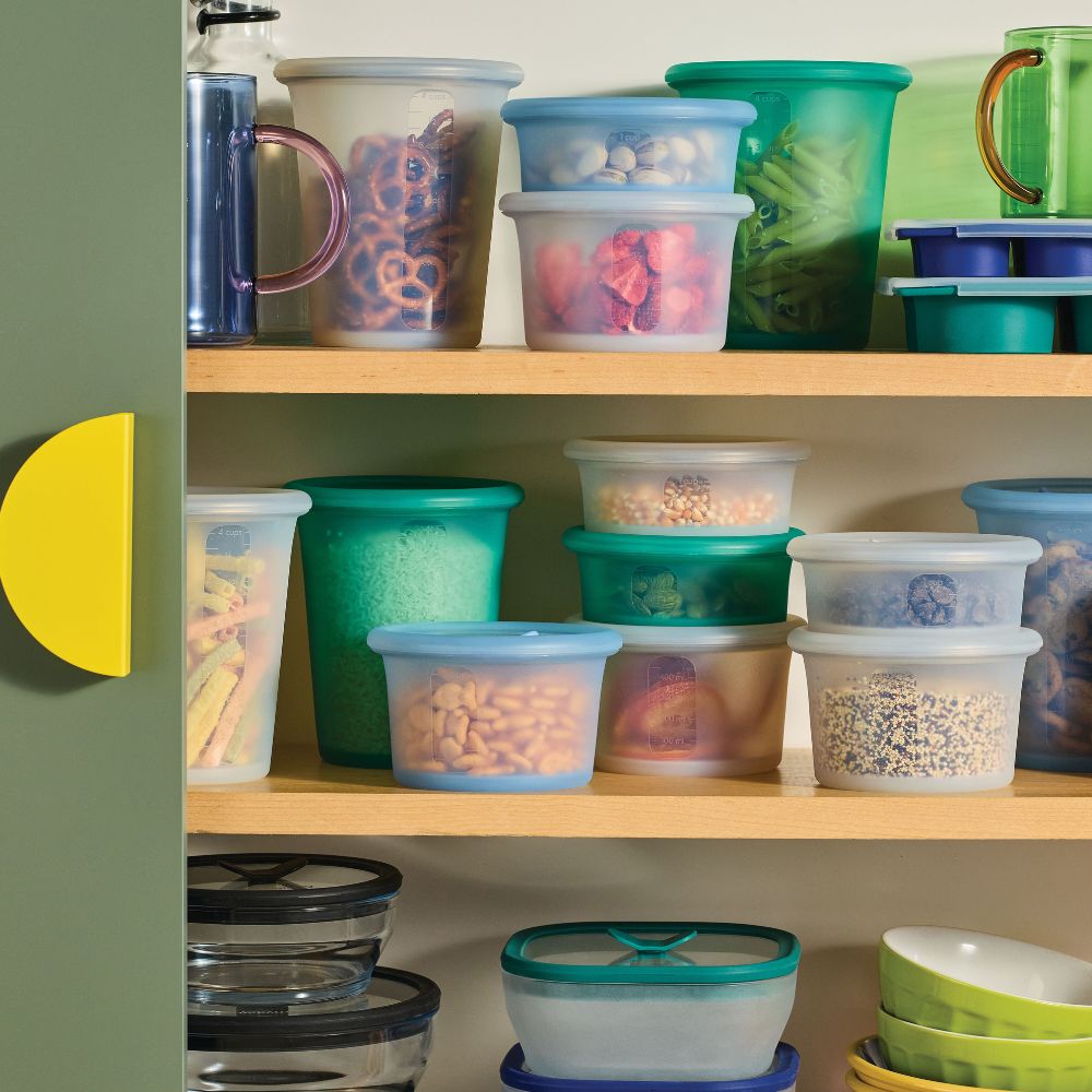 Colorful Anydeli silicone containers organized on wooden kitchen shelves