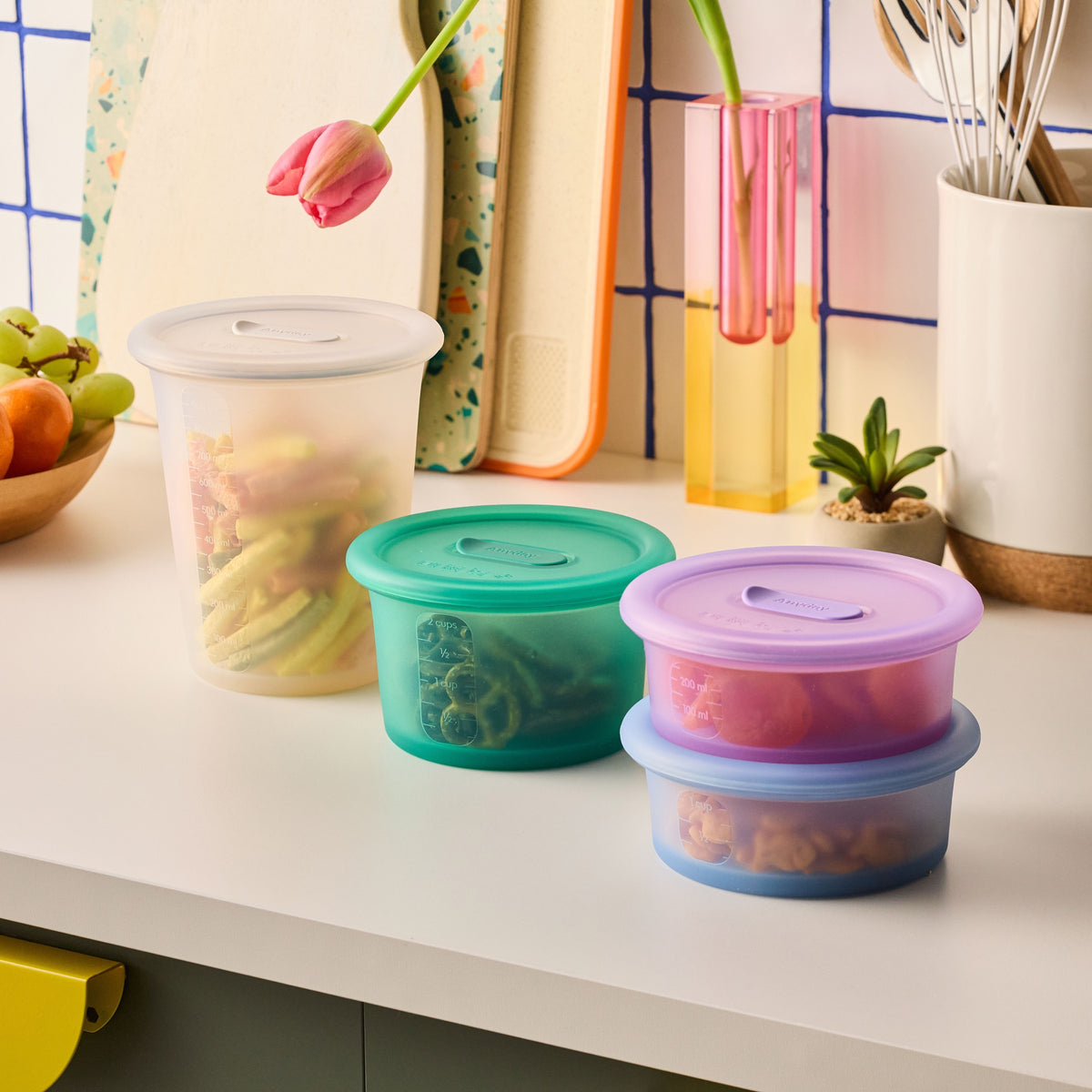 Anydeli containers in Mochi, Basil, Ube and Ice holding food on a kitchen counter